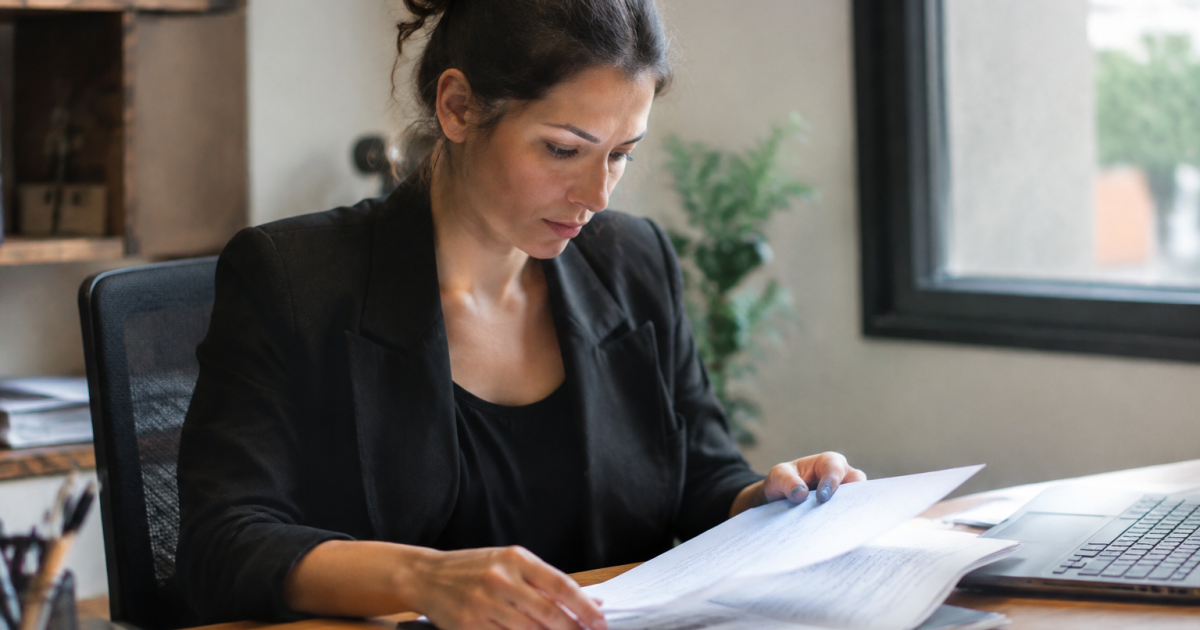 Femme consultant documents contrats assis table bureau