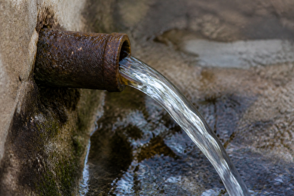 Eau sortant d'un tuyau metallique oxyde