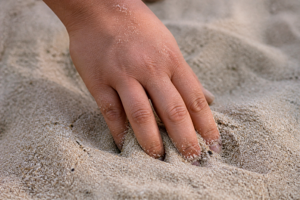Grains sable fin texture reguliere doigts