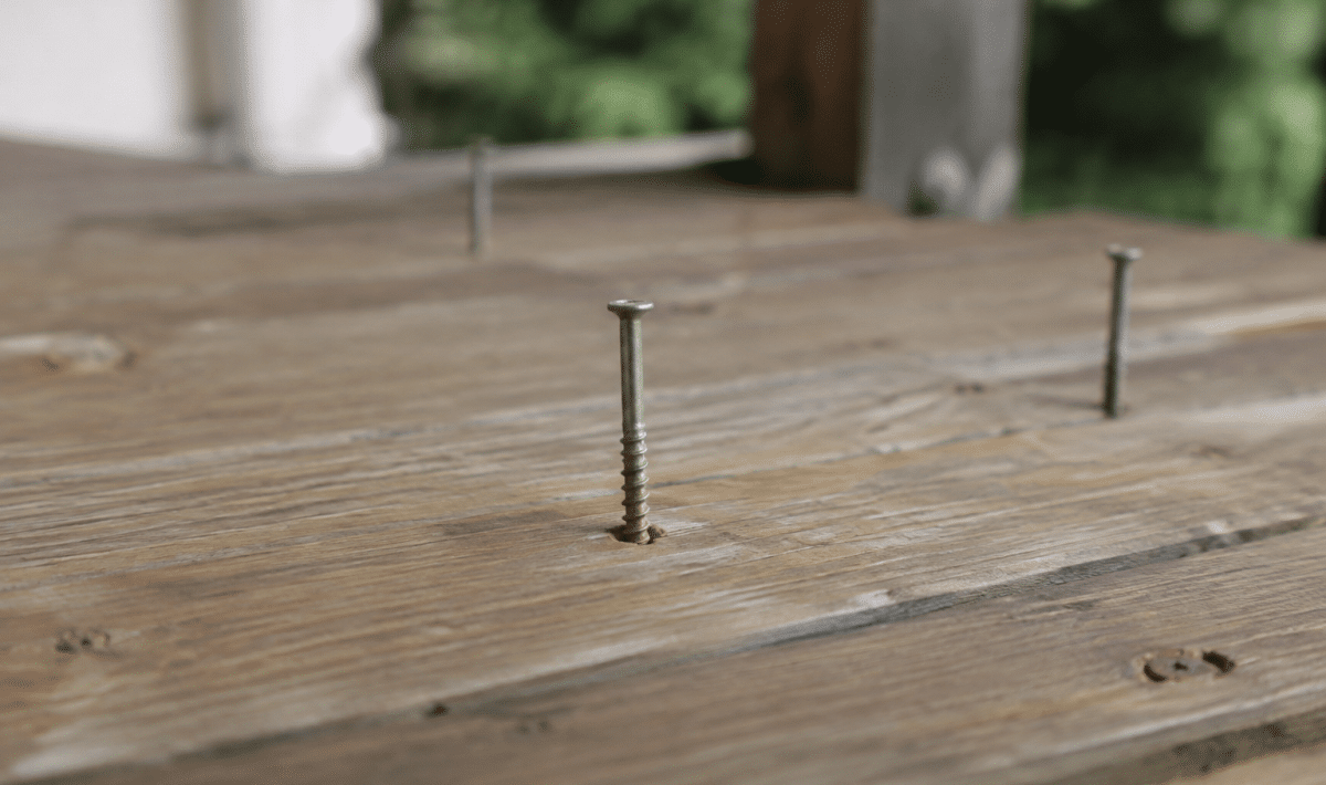 Vis metalliques enfoncees verticalement dans bois terrasse