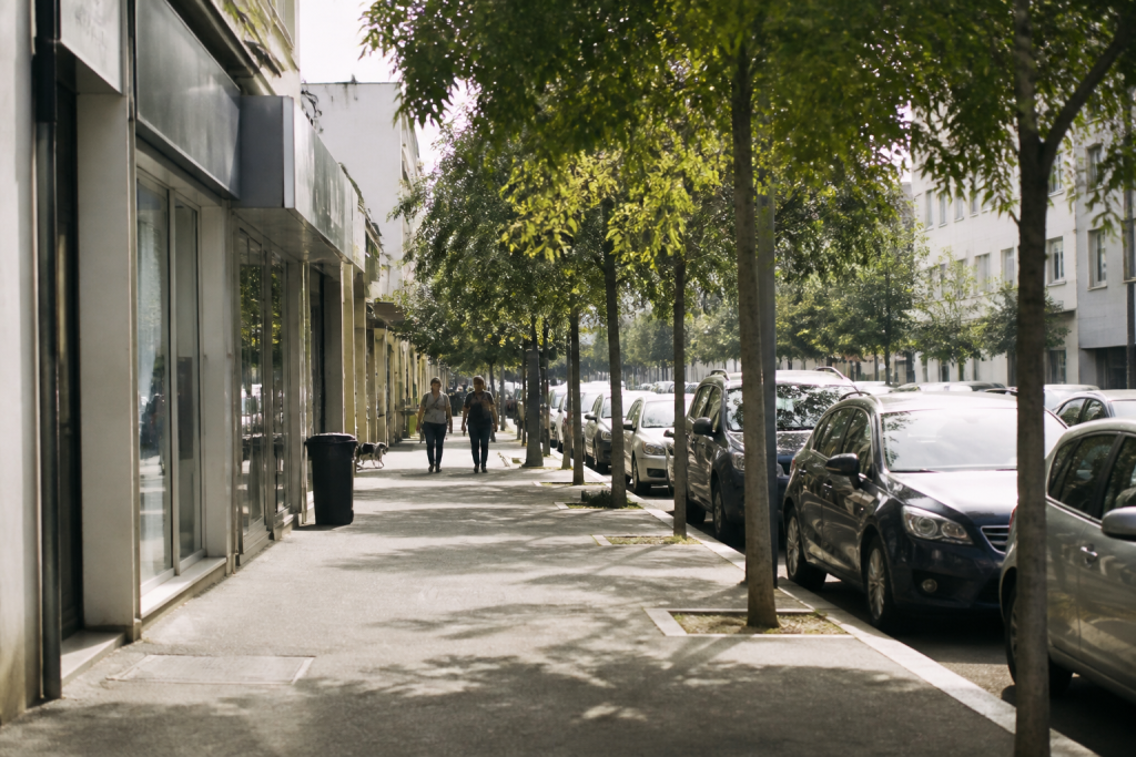 Rue urbaine bien eclairee avec commerces et parking