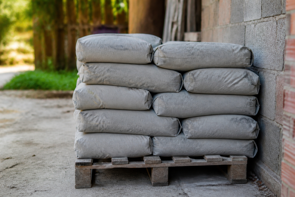 Sacs ciment gris empiles sur palette bois